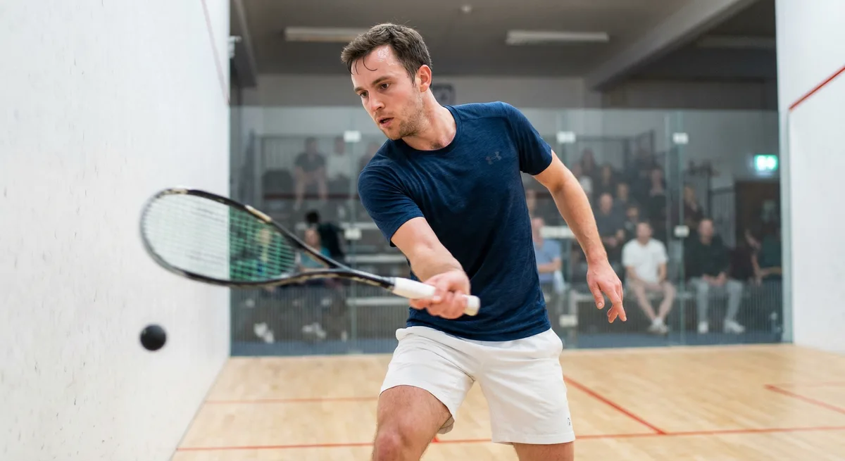 A squash player executing a precise shot on the court
